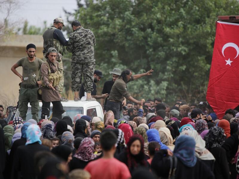 Members of Turkey-backed forces distribute aid provided by the Turkish Red Crescent on October 19, 2019, in the Syrian border town of of Tal Abyad which was seized last week. Bakr ALKASEM / AFP