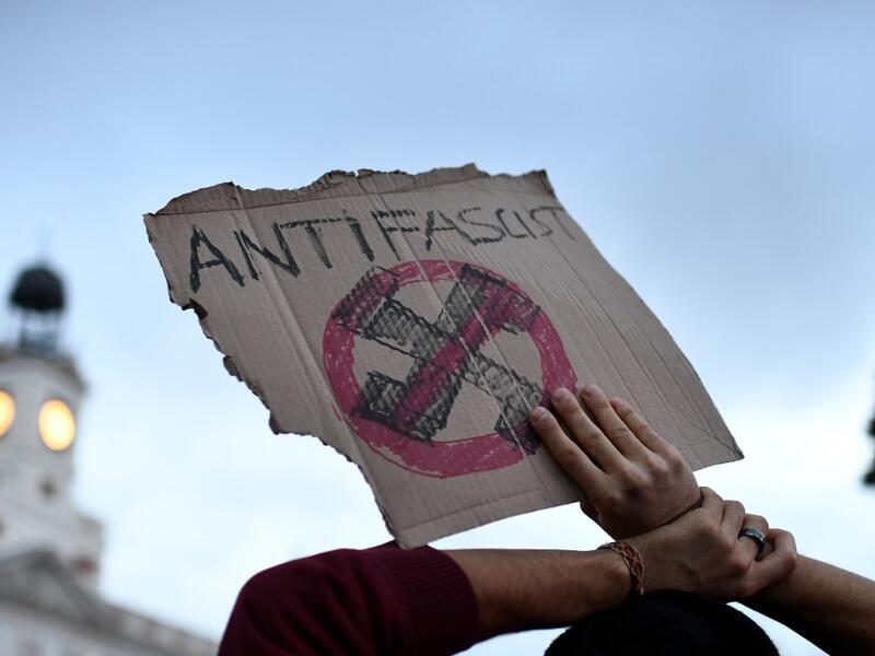 A protester holds up a sign with an anti-fascist symbol during a pro-amnesty demonstration called by Madrid's Anti-repression Movement and demanding total amnesty and the defence of democratic rights and freedoms in Madrid on October 19, 2019. OSCAR DEL POZO / AFP