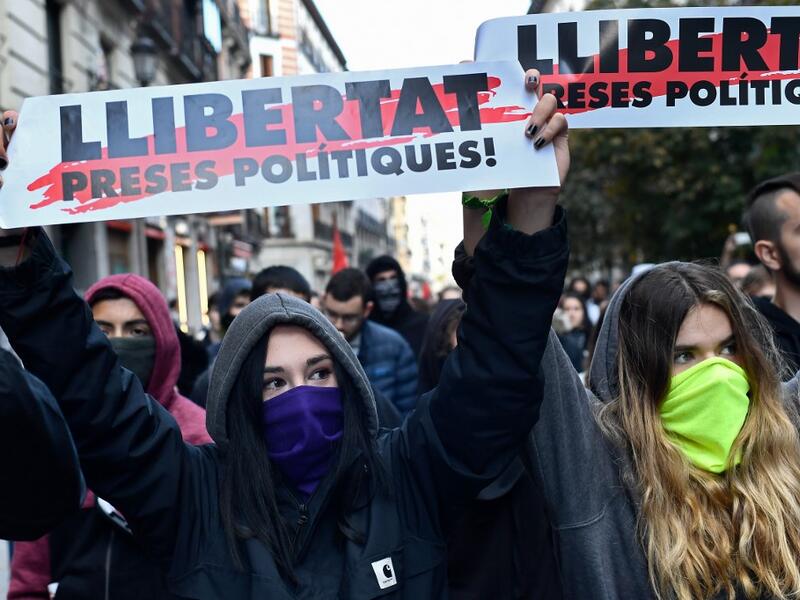 Protesters hold banners reading in Catalan "Freedom for politic prisoners!" during a pro-amnesty demonstration called by Madrid's Anti-repression Movement and demanding total amnesty and the defence of democratic rights and freedoms in Madrid on October 19, 2019. AFP