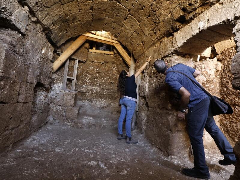 Timnah Goloubin (L), an archaeologist with the Israel Antiquities Authority, shows on October 23, 2019 the ancient church crypt in the Israeli city of Bet Shemesh. A magnificent 1500-year-old church, decorated with spectacular mosaic floors and Greek inscriptions, was discovered during a three-year excavation near a residential area. MENAHEM KAHANA / afp