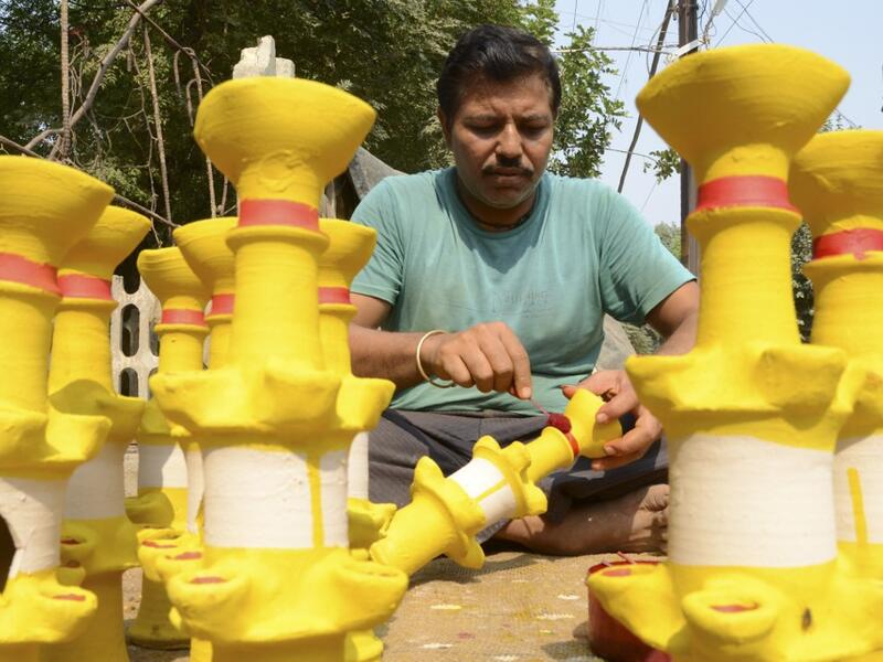 A craftsman paints earthen lamps ahead of the Hindu festival of Diwali in Amritsar on October 25, 2019.  NARINDER NANU / AFP