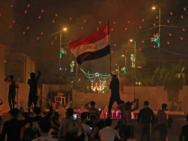 An Iraqi protester waves the national flag during an anti-government demonstration in the Shiite shrine city of Karbala, south of Iraq's capital Baghdad, on October 25, 2019. Two dozen demonstrators were killed in renewed rallies across Baghdad and Iraq's south today by live rounds and tear gas, according to a national rights watchdog. AFP