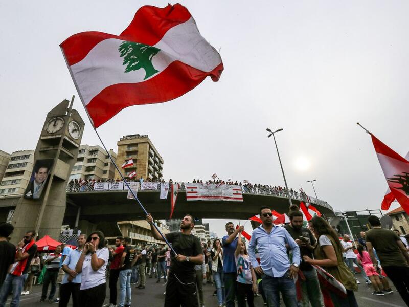A man waves a Lebanese national flag during a demonstration on the highway that links the capital Beirut to the northern city of Tripoli, in the area of Jal el-Dib in the northeastern outskirts of the capital, on October 26, 2019 on the tenth day of protest against tax increases and official corruption. (JOSEPH EID / AFP) A man waves a Lebanese national flag during a demonstration on the highway that links the capital Beirut to the northern city of Tripoli, in the area of Jal el-Dib in the northeastern outskirts of the capital, on October 26, 2019 on the tenth day of protest against tax increases and official corruption. (JOSEPH EID / AFP)