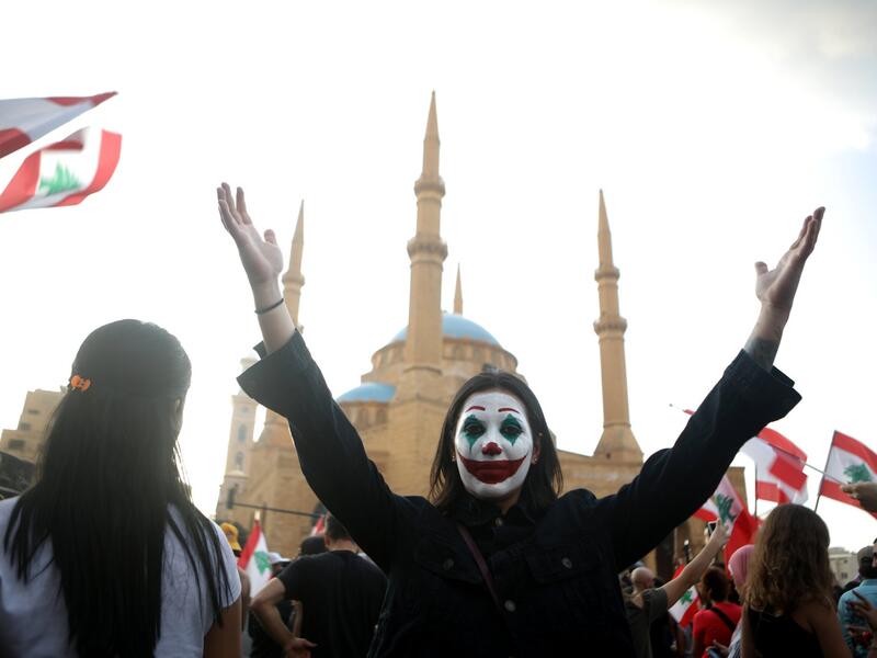 A Lebanese demonstrator, her face painted as DC comic book and film character "The Joker", takes part in a protest in the capital Beirut's downtown district's Martyr's Square (Twitter)