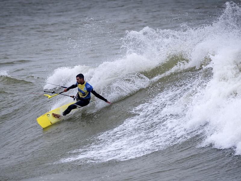 A picture taken on October 10, 2019, shows a kitesurfer riding waves at Dakhla beach in Morocco-administered Western Sahara. In the heart of disputed Western Sahara, a former garrison town has become an unlikely tourist magnet after kitesurfers discovered the windswept desert coast on the Atlantic is perfect for their sport. FADEL SENNA / AFP