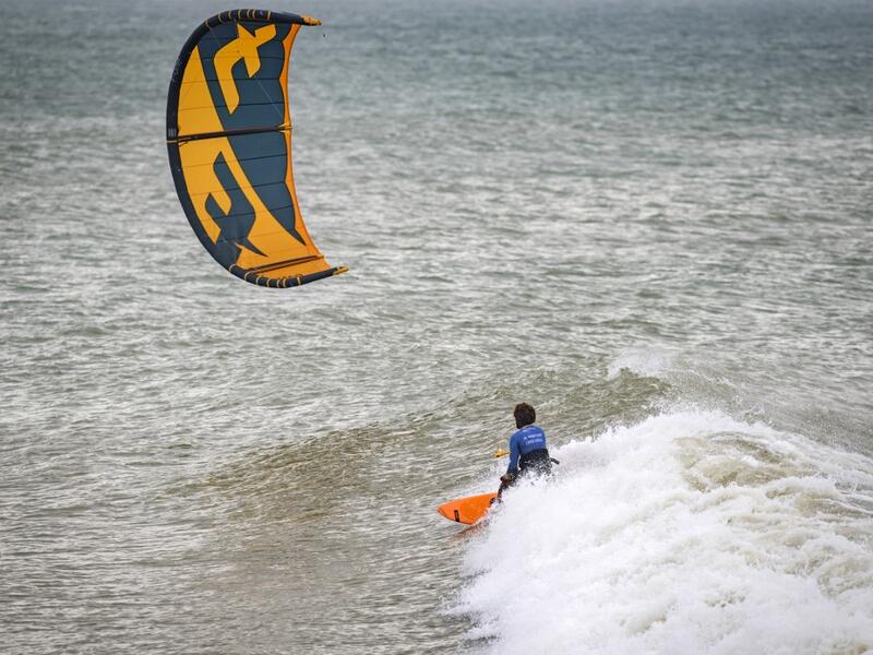 A picture taken on October 10, 2019, shows a kitesurfer riding waves at Dakhla beach in Morocco-administered Western Sahara. In the heart of disputed Western Sahara, a former garrison town has become an unlikely tourist magnet after kitesurfers discovered the windswept desert coast on the Atlantic is perfect for their sport. FADEL SENNA / AFP