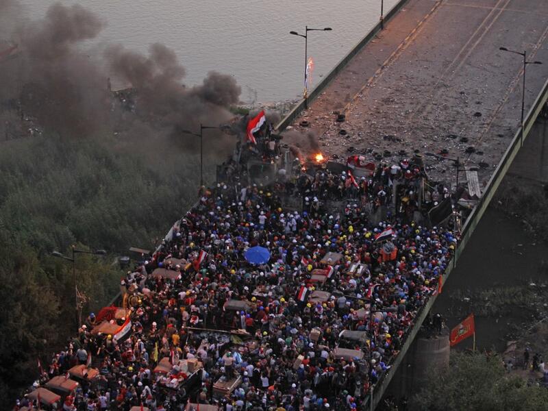 Iraqi protesters gather on al-Jumhuriya bridge which leads to the high-security Green Zone, during ongoing anti-government demonstrations in the capital Baghdad on October 31, 2019. Iraq's president vowed today to hold early elections in response to a month of deadly protests, but demonstrators said the move fell far short of their demands for a political overhaul. AHMAD AL-RUBAYE / AFP