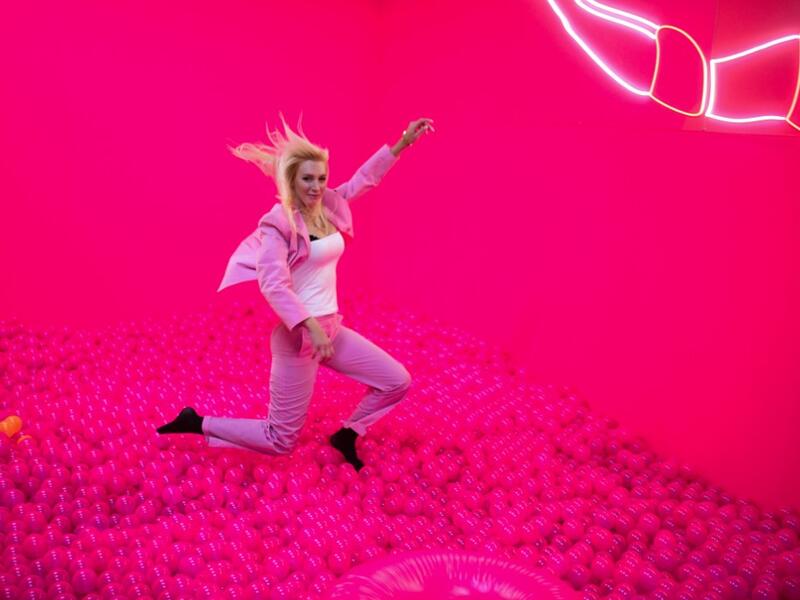 A woman jumps into a ball bath at the "Supercandy Pop-Up Museum Vol. 2" in Cologne, western Germany on November 1, 2019. It is an interactive museum and offers a photo backdrop for social media at 25 stations. INA FASSBENDER / AFP