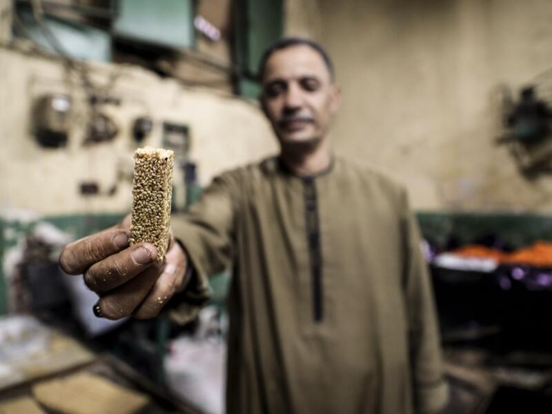An Egyptian confectioner shows a sweet sesame bar at a candy factory in the capital Cairo on November 2, 2019, ahead of celebrations of the Muslim Prophet Mohammed's birthday, known as "Al Mawlid Al Nabawi". Prophet Mohamed was born in Saudi Arabia's arid mountainous city of Mecca, the holiest in Islam, some 1490 years ago. Sunni Muslims in many parts of the world celebrate his birthday on the 12th day of the third month of the Islamic calendar, which will fall this year on November 9th.  Mohamed el-Shahed 