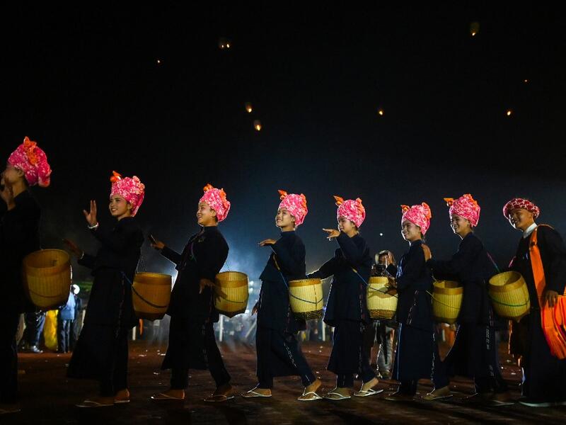 This picture taken on November 4, 2019 shows Pa-O ethnic women performing a traditional dance during the opening ceremony of the Tazaungdaing Lighting Festival at Taunggyi in Myanmar's northeastern Shan State. Brightly coloured balloons with hundreds of homemade fireworks woven into their frames are sent soaring into the night sky, showering down cascades of sparks onto adoring crowds in the annual Taunggyi fire balloon festival. Ye Aung THU / AFP