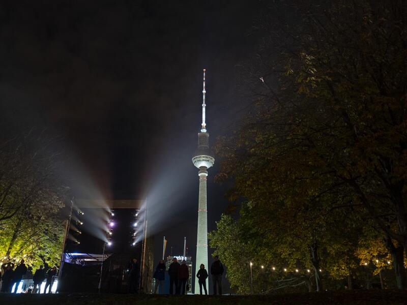 People look at a light show projected onto the Humboldt Forum building as part of the festival week to celebrate the 30th anniversary of the November 9,1989 fall of the Berlin Wall, in Berlin on November 5, 2019. Germany marks three decades since the fall of the Berlin Wall this week with main celebrations on November 9, 2019. John MACDOUGALL / AFP