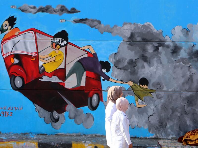 Young Iraqis walk past colourful murals in Baghdad's Tahrir Square as the Iraqi capital braces for another day of anti-government protests on November 6, 2019. A mounting death toll in Baghdad and across southern Iraq coupled with renewed internet restrictions sparked fears that anti-government protests would once again trigger chaos. SABAH ARAR / AFP