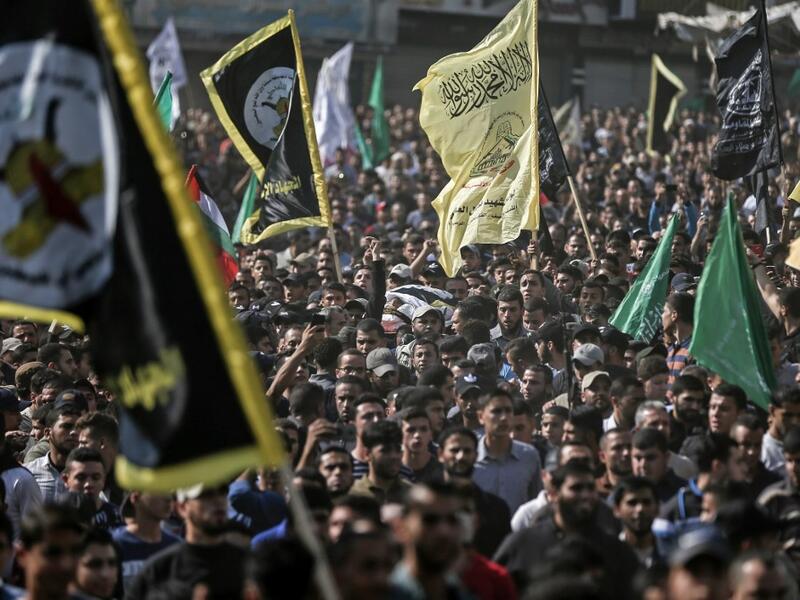 Mourners chant slogans as they carry the body of Palestinian Islamic Jihad senior leader Baha Abu Al-Ata during his funeral in Gaza City on November 12, 2019. Israel's military killed a commander of Palestinian militant group Islamic Jihad in a strike on his home in the Gaza Strip early, prompting retaliatory rocket fire and fears of a severe escalation in violence. MAHMUD HAMS / AFP