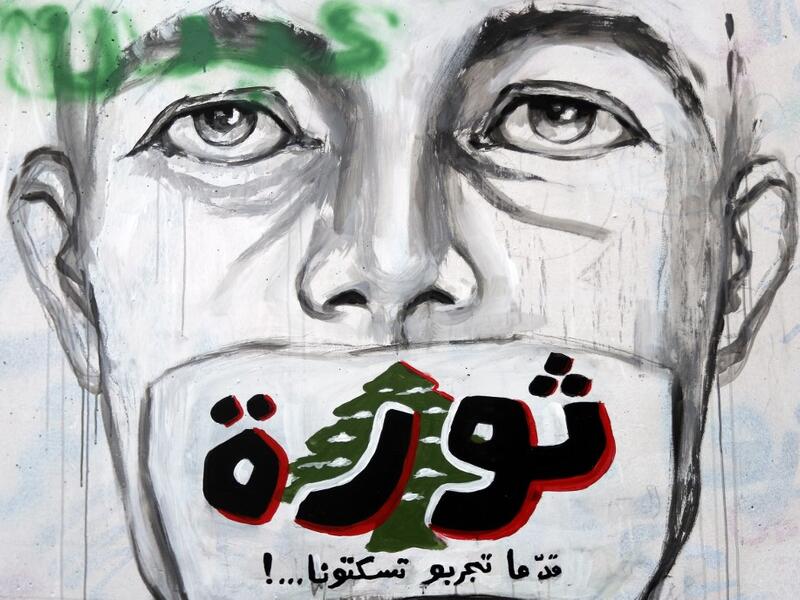 A graffiti reading "Revolution...even if you try to silence us" is sprayed on a wall in central Beirut on November 5, 2019. Since October 17, the chanting of tens of thousands of Lebanese denouncing the political elite have shaken the normally staid district around two Beirut squares, Martyrs' and Riad Al Solh. JOSEPH EID / AFP