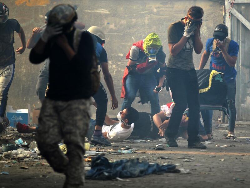 Iraqi protesters react to tear gas amid clashes with security forces at Baghdad's Khallani square during ongoing anti-government demonstrations on November 12, 2019. (AFP/ File Photo)