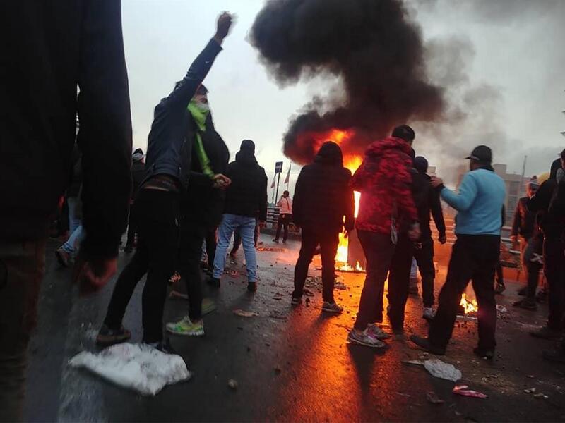 Iranian protesters gather around a fire during a demonstration against an increase in gasoline prices in the capital Tehran, on November 16, 2019. One person was killed and others injured in protests across Iran, hours after a surprise decision to increase petrol prices by 50 percent for the first 60 litres and 300 percent for anything above that each month, and impose rationing. Authorities said the move was aimed at helping needy citizens, and expected to generate 300 trillion rials ($2.55 billion) per an