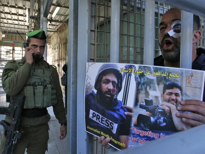 A Palestinian demonstrator takes part in a demonstration in support of Muath Amarneh, a photographer who was hit in the eye last week during clashes between Israeli border police and Palestinian demonstrators in the village of Surif, in front an Israeli checkpoint in the divided Palestinian city of Hebron on November 18, 2019. HAZEM BADER / AFP