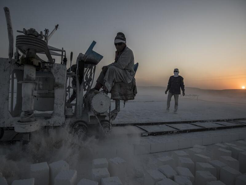 Labourers work at the "White Mountain" limestone extraction quarry site near Egypt's southern city of Minya, some 265 kilometres south of the capital, on November 13, 2019. Covered in fine white dust, labourers at the so-called "White Mountain" off Minya toil in shifts amidst brutal conditions with little workplace safety for paltry pay. They handle dangerous machinery with finesse, and shrug off the dangers of a job where a mistake can prove fatal. Khaled DESOUKI / AFP