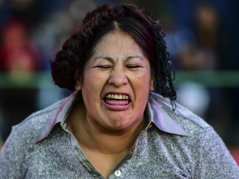 Bolivian wrestler Ana Luisa Yujra, aka "Jhenifer Two Faces", member of the Fighting Cholitas, grimaces during a bout at Sharks of the Ring wrestling club in El Alto, Bolivia, on November 24, 2019. After a fortnight hiatus due to anti-government protests and blockades, the Fighting Cholitas are back in the ring. The unrest was triggered by the disputed October 20 election, which Evo Morales claimed to have won and opposition groups said was rigged. Ronaldo SCHEMIDT / AFP