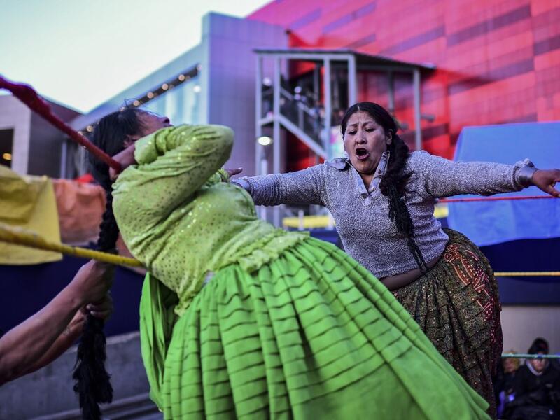 Bolivian wrestler Ana Luisa Yujra (R), aka "Jhenifer Two Faces" and Lidia Flores, aka "Dina, The Queen of the Ring", both members of the Fighting Cholitas, fight at Sharks of the Ring wrestling club in El Alto, Bolivia, on November 24, 2019. After a fortnight hiatus due to anti-government protests and blockades, the Fighting Cholitas are back in the ring. The unrest was triggered by the disputed October 20 election, which Evo Morales claimed to have won and opposition groups said was rigged. Ronaldo SCHEMID