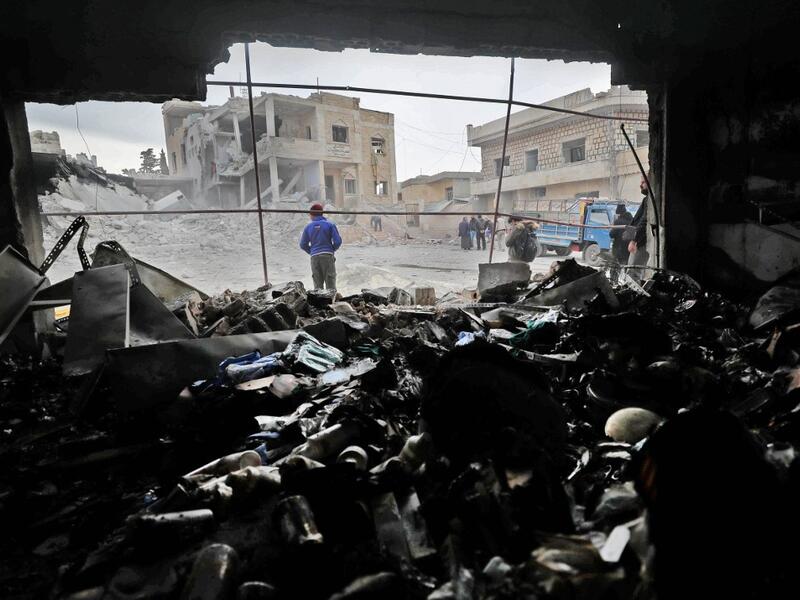 Syrians walk amidst rubble following reported airstikes by pro-regime forces in the town of Kansafrah, in the south of the Idlib province on November 25, 2019. (Omar HAJ KADOUR / AFP)