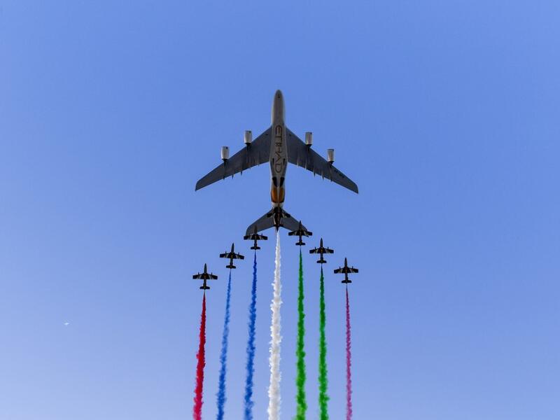 UAE elite aerobatic flying team "Al Fursan" escorts an Etihad A380 aircraft as they fly over the Yas Marina Circuit in Abu Dhabi, ahead of the final race of the Formula One Grand Prix season, on December 1, 2019. ANDREJ ISAKOVIC / AFP