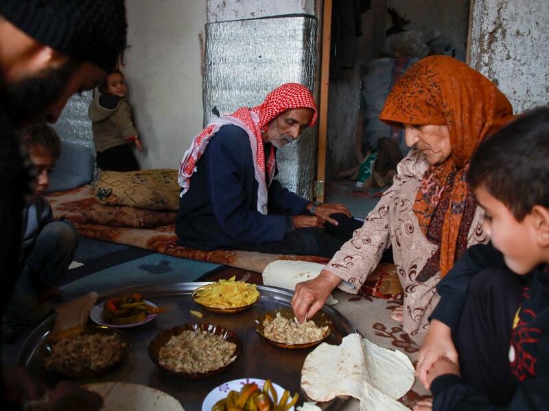 Umm Khaled and her family share a meal in a camp in a town called Haarem in the northwestern province of Idlib on November 29, 2019. Aaref WATAD / AFP