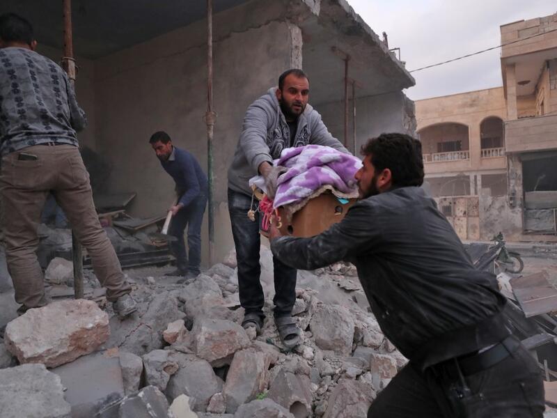 Residents salvage belongings from the rubble of a building following a reported air strike by pro-regime forces in the Syrian town of Saraqib in the northwestern Idlib province on December 4, 2019. (Omar HAJ KADOUR / AFP)