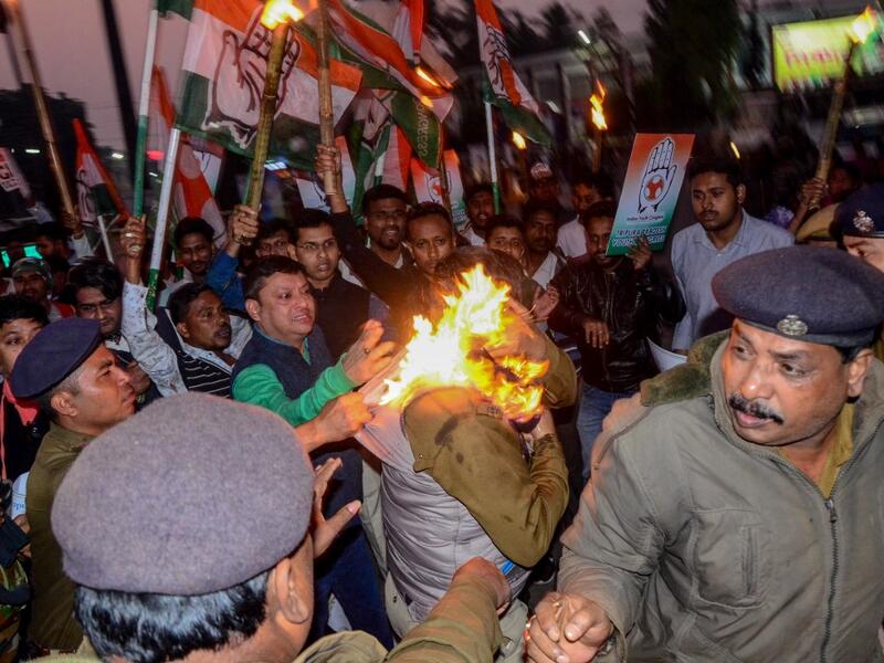 Police personnel try to rescue a police officer (C) caught on fire during a protest against the government's Citizenship Amendment Bill (CAB) in Agartala, the capital of India's northeastern state of Tripura on December 11, 2019. (AFP/ File Photo)
