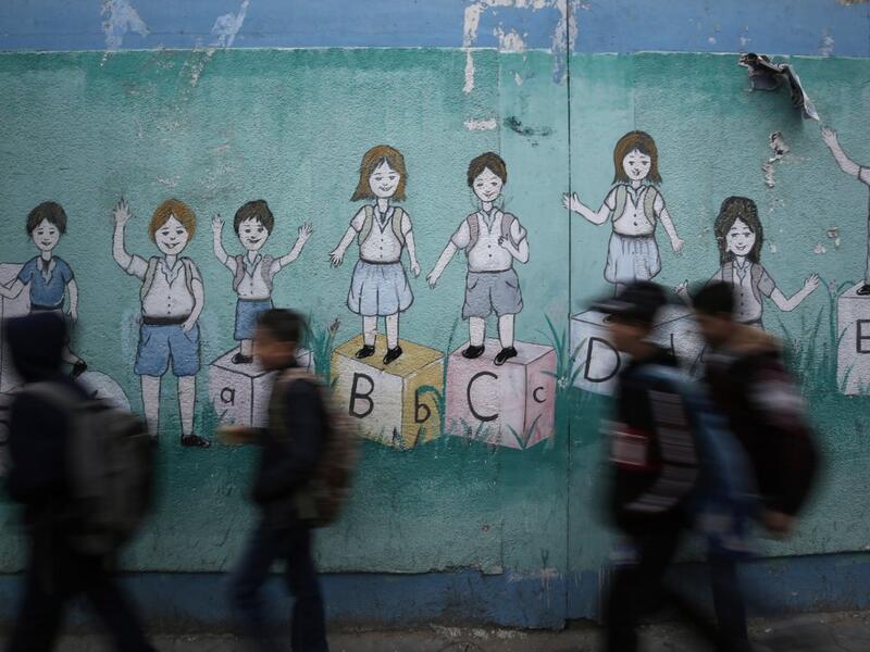 Palestinian children walk past a mural on their way to their United Nations-run school in Al-Shati refugee camp in Gaza City, on December 14, 2019. MOHAMMED ABED / AFP Palestinian children walk past a mural on their way to their United Nations-run school in Al-Shati refugee camp in Gaza City, on December 14, 2019. MOHAMMED ABED / AFP