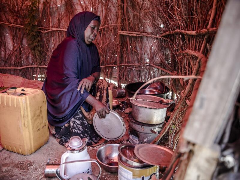 A displaced woman, who was forced to leave her house due to heavy rains and floods in the area, cooks a meal at a displacement camp for families affected by floods located in Beledweyne, Somalia, on December 14, 2019. The rains have inundated big areas surrounding Beledweyne area forcing thousands of people to leave their houses and look for humanitarian assistance while living in displacement camps. Due to climate change and human activities, floods have become more recurrent and completely unpredictable i