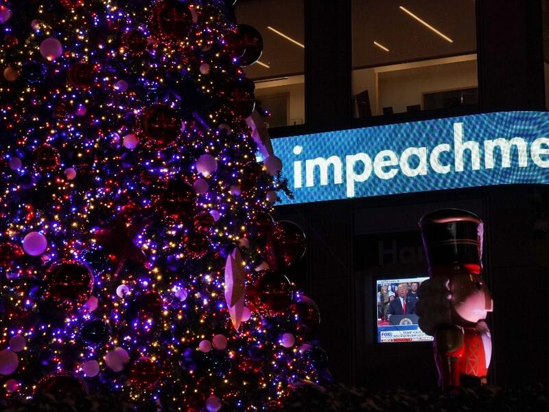 US President Donald Trump is shown on a screen speaking from a rally in Michigan as the the Fox News Headquarters ticker flashes the news of his impeachment for abuse of power in New York on December 18, 2019. US President Donald Trump was impeached for abuse of power in a historic vote in the House of Representatives on December 18, 2019, setting up a Senate trial on removing him from office after three turbulent years. TIMOTHY A. CLARY / AFP