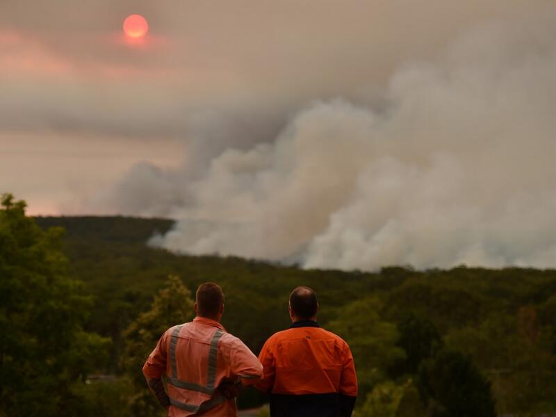 Residents watch a large bushfire as seen from Bargo, 150km southwest of Sydney, on December 19, 2019. A state of emergency was declared in Australia's most populated region on December 19 as an unprecedented heatwave fanned out-of-control bushfires, destroying homes and smothering huge areas with a toxic smoke. Peter PARKS / AFP