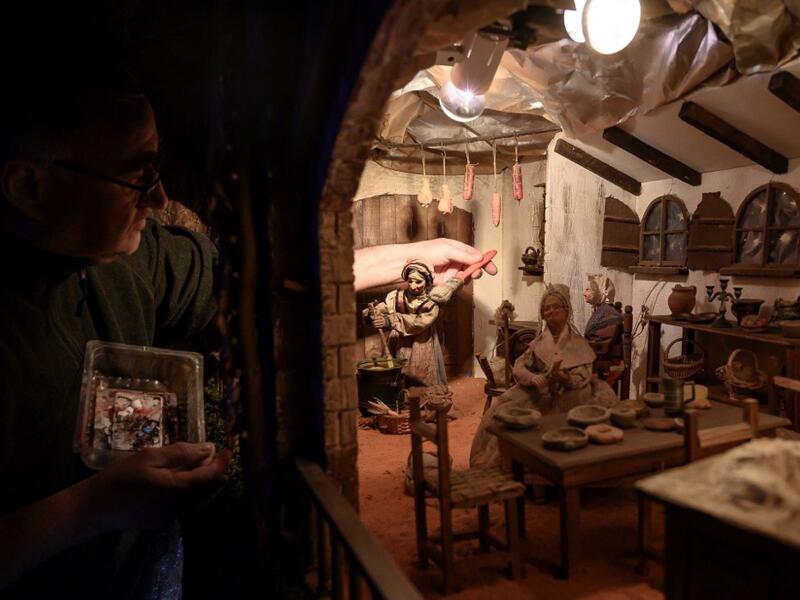 Volunteer Ilario Geuna cleans a nativity figure at the 43rd edition of the "Presepio of Cavallermaggiore", a 300sqm Christmas Nativity crib in the Oratorio San Michele on December 20, 2019 in Cavallermaggiore, near Cuneo, Northwestern Italy. The "Presepio" is made by ten volunteers who every year spend 3 months to build a new edition with hundred of figures. MARCO BERTORELLO / AFP