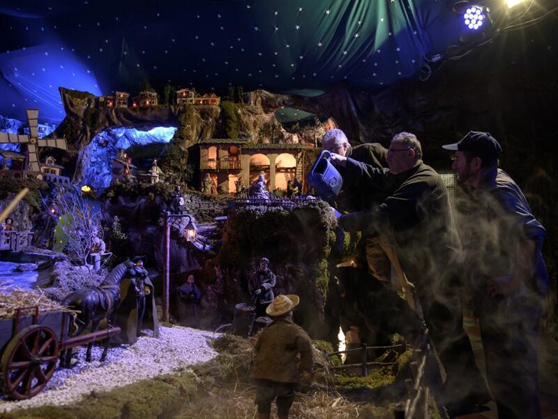 Volunteers set nativity figures at the 43rd edition of the "Presepio of Cavallermaggiore", a 300sqm Christmas Nativity crib in the Oratorio San Michele on December 20, 2019 in Cavallermaggiore, near Cuneo, Northwestern Italy. The "Presepio" is made by ten volunteers who every year spend 3 months to build a new edition with hundred of figures. MARCO BERTORELLO / AFP