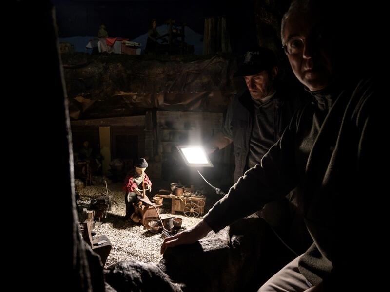 Volunteers Mario Curcetti and Dario Assie prepare figures for the "Presepio of Cavallermaggiore", a 300sqm Christmas Nativity crib in the Oratorio San Michele, are pictured at its 43rd edition on December 20, 2019 in Cavallermaggiore, near Cuneo, Northwestern Italy. The "Presepio" is made by ten volunteers who every year spend 3 months to build a new edition with hundreds of figures. MARCO BERTORELLO / AFP