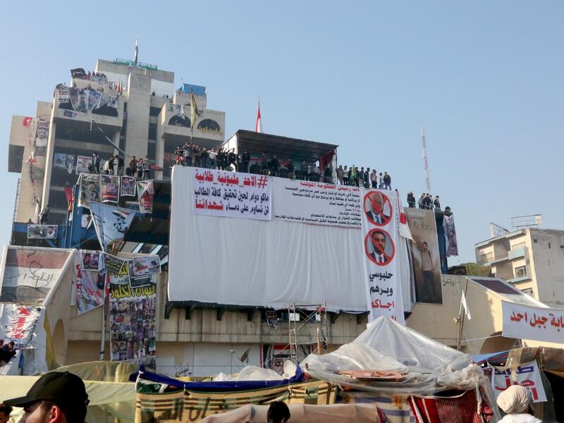 Iraqi anti-government protesters rally during ongoing demonstrations in the capital Baghdad's Tahrir square (AFP)