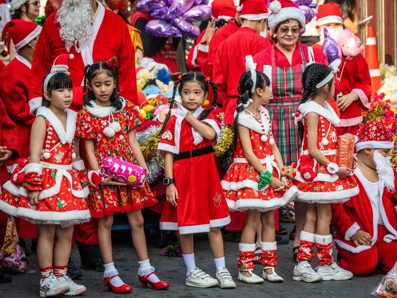 Children in Christmas costumes wait to receive gifts from elephants dressed in Santa Claus costumes during Christmas celebrations in Ayutthaya on December 23, 2019. Wearing red and white hats and a string of bells, Thai elephants passed out Christmas gifts to hundreds of schoolchildren on Monday despite growing criticism over using the animals in performances. The annual festive event is organised by a nearby elephant park, whose mahouts or handlers started in the early morning dressing the animals. Thailan