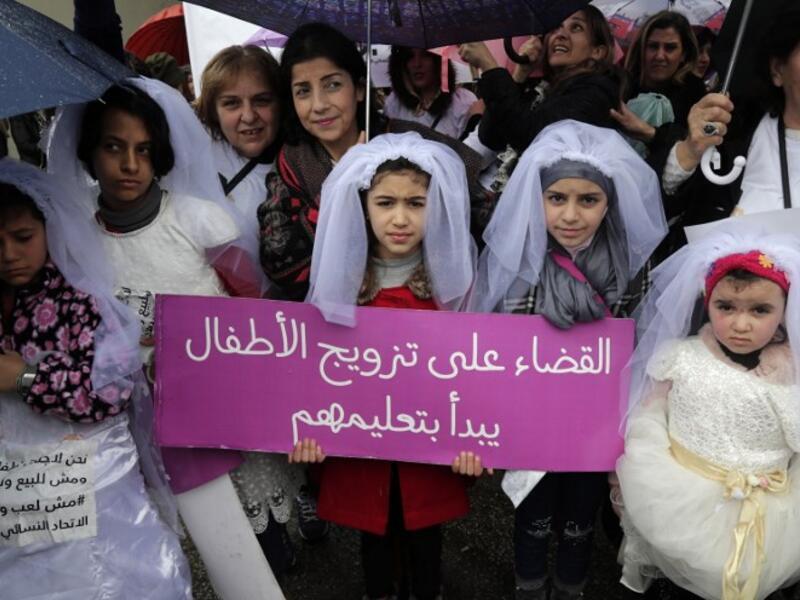 Young Lebanese girls disguised as brides hold a placard as they participate in a march against marriage before the age of 18, in the capital Beirut on March 2, 2019. (AFP/ File Photo)