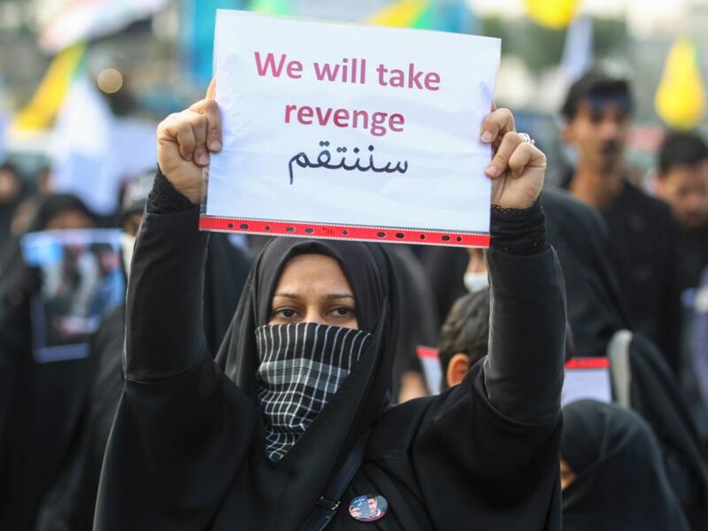 An Iraqi woman holds a placard during the funeral of Iranian military commander Qasem Soleimani, Iraqi paramilitary chief Abu Mahdi al-Muhandis and eight others in Baghdad's district of al-Jadriya, in Baghdad's high-security Green Zone, on January 4, 2020. (AFP/ File Photo)