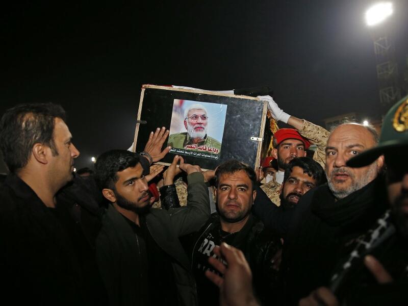 People carry the casket of Iraqi paramilitary chief Abu Mahdi al-Muhandis upon arrival at Ahvaz International Airport in southwestern Iran on January 5, 2020. A tide of mourners packed the streets of the Iranian city of Ahvaz Sunday to pay respects to top general Qasem Soleimani, days after he was killed in a US strike. HOSSEIN MERSADI / fars news / AFP