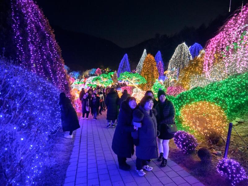 In a photo taken on January 11, 2020 visitors look at an annual light display at the 'Garden on Morning Calm', near Gapyeong, east of Seoul. Ed JONES / AFP