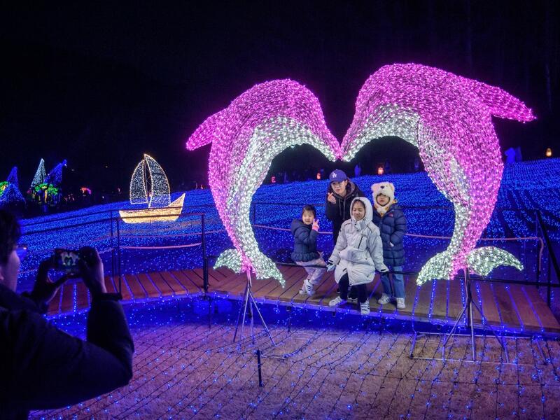 In a photo taken on January 11, 2020 visitors look at an annual light display at the 'Garden on Morning Calm', near Gapyeong, east of Seoul.