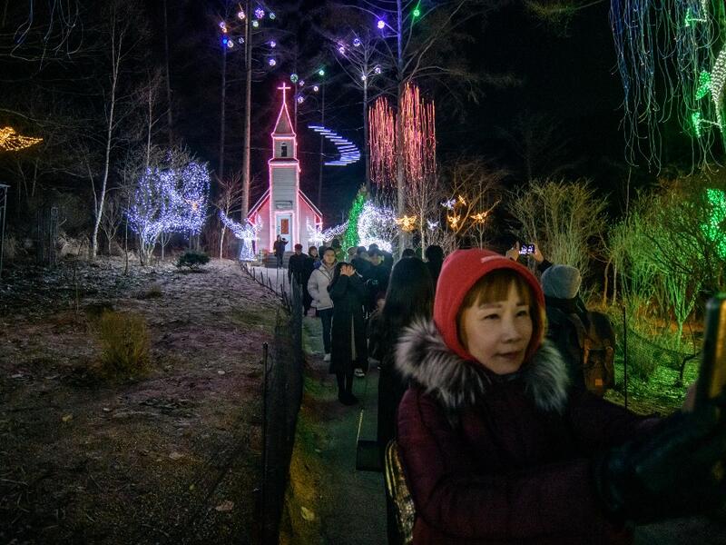 In a photo taken on January 11, 2020 visitors look at an annual light display at the 'Garden on Morning Calm', near Gapyeong, east of Seoul. Ed JONES / AFP
