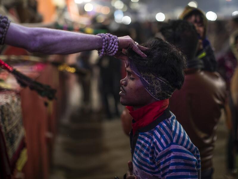 A Sadhu (Hindu holy man) blesses a pilgrim during the Gangasagar Mela, at Sagar Island, some 150 kilometres south of Kolkata on January 14, 2020. XAVIER GALIANA / AFP