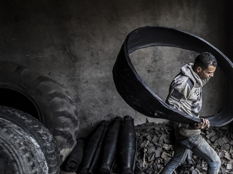 A labourer carries a ripped-out tyre liner at a rubber recycling workshop in the village of Mit al-Harun in Egypt's central Nile delta Gharbia Governorate, about 70 kilometres (43 miles) north of the capital, on January 14, 2020. Khaled DESOUKI / AFP