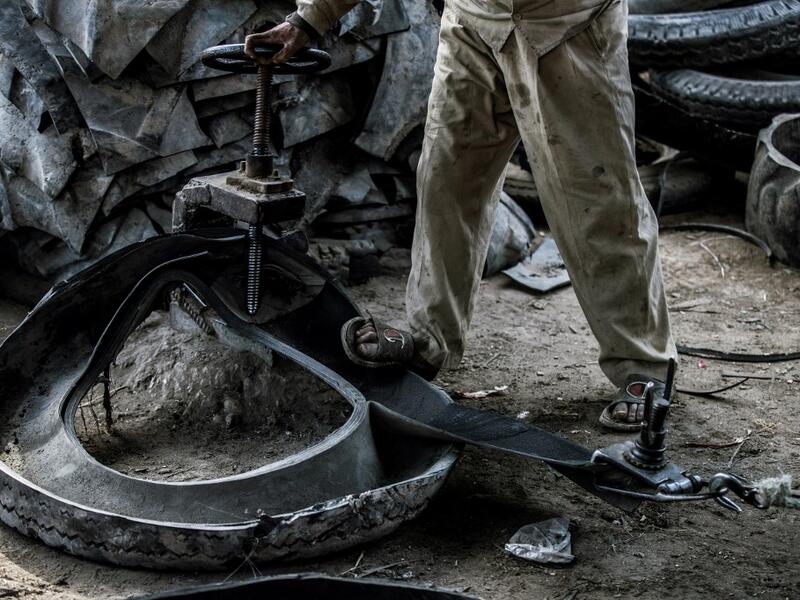 A labourer deconstructs a tyre at a rubber recycling workshop in the village of Mit al-Harun in Egypt's central Nile delta Gharbia Governorate, about 70 kilometres (43 miles) north of the capital, on January 14, 2020. Khaled DESOUKI / AFP