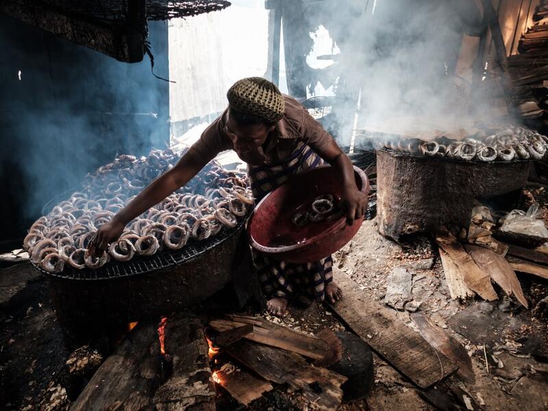 A picture taken on March 1, 2019 shows a woman smoking fish in the Makoko waterfront community in a polluted lagoon in Lagos, Africa’s biggest megalopolis in Nigeria. The sprawling community began in the 19th century as a fishing village for immigrants who settled on the water's edge. As more arrived and land became rare, people started to move out onto the water. Over time, Makoko became a floating realm of perhaps a quarter of a million people, although the real number is anyone's guess. YASUYOSHI CHIBA /
