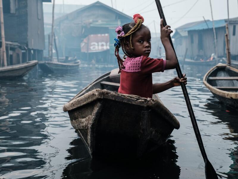 A picture taken on March 1, 2019 shows a girl steering a boat on a waterway in the Makoko waterfront community in a polluted lagoon in Lagos, Africa’s biggest megalopolis in Nigeria. The sprawling community began in the 19th century as a fishing village for immigrants who settled on the water's edge. As more arrived and land became rare, people started to move out onto the water. Over time, Makoko became a floating realm of perhaps a quarter of a million people, although the real number is anyone's guess. Y
