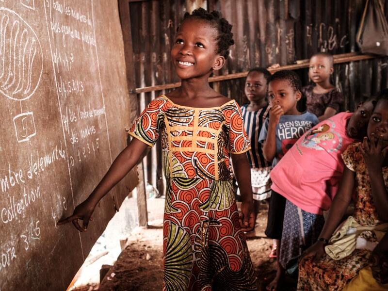 A picture taken on March 1, 2019 shows a student next to a board at a private school in the Makoko waterfront community in a polluted lagoon in Lagos, Africa’s biggest megalopolis in Nigeria. The sprawling community began in the 19th century as a fishing village for immigrants who settled on the water's edge. As more arrived and land became rare, people started to move out onto the water. Over time, Makoko became a floating realm of perhaps a quarter of a million people, although the real number is anyone's
